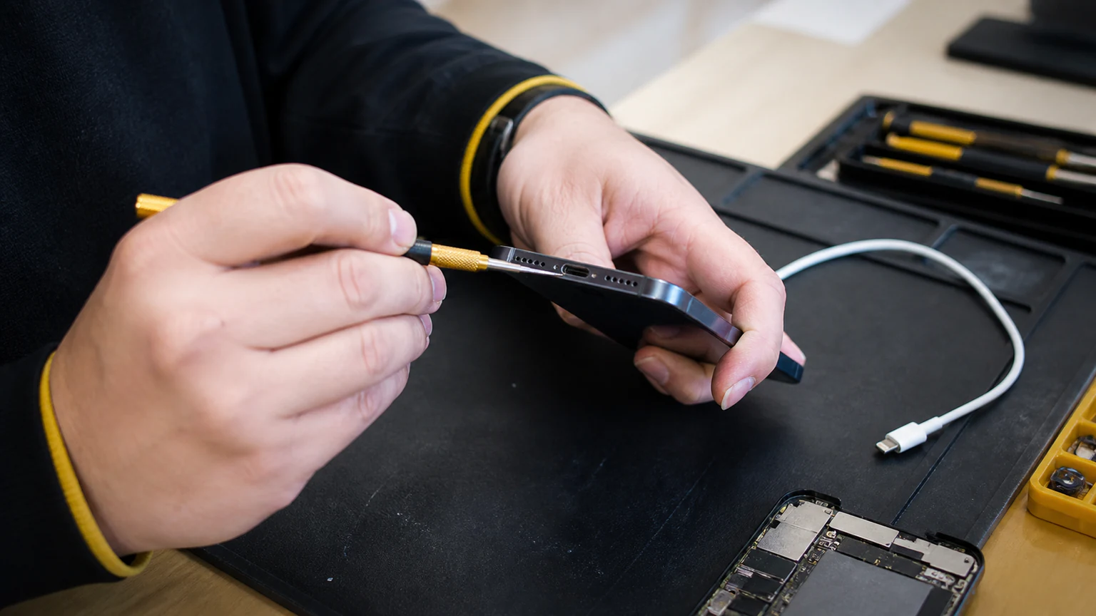 Technician inspecting a smartphone charging port that will not charge