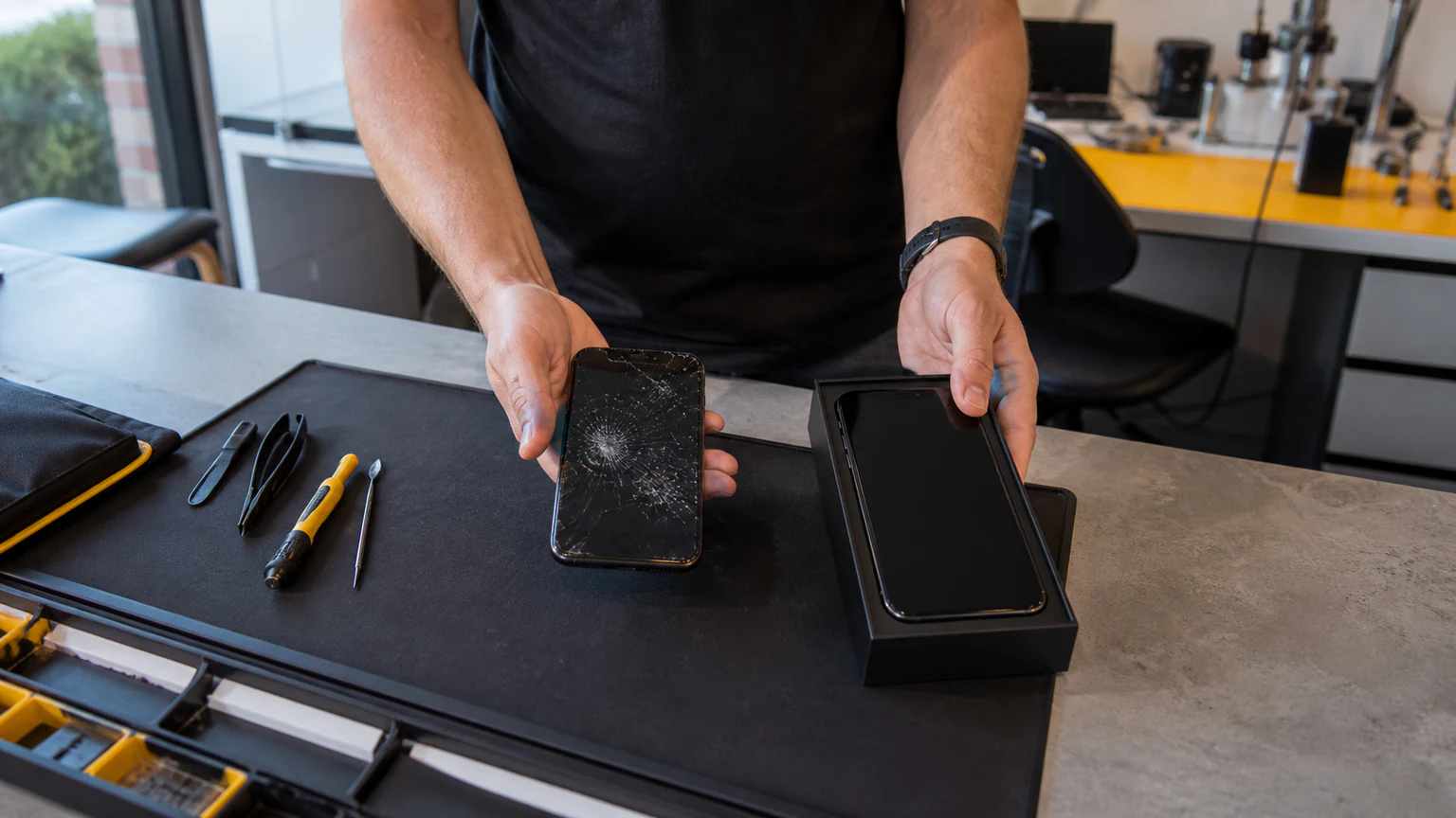 Customer comparing a damaged phone with a new replacement device